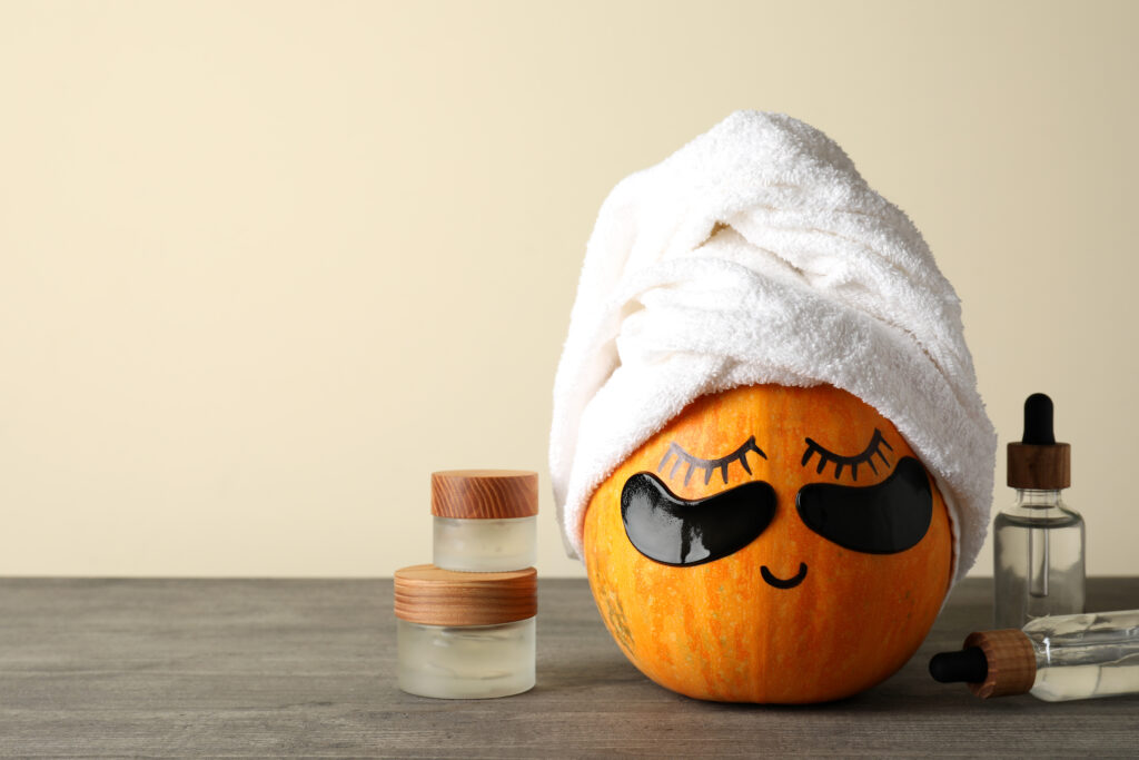 seasonal social media ideas. Concept of body care with pumpkin on gray textured table