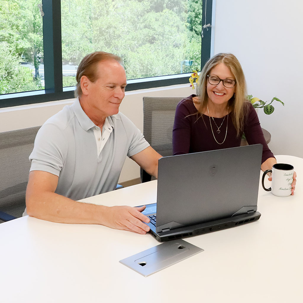 Charles and Annette looking at a laptop - 360 Web Designs Management Team leaders