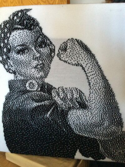 A classic poster translated to a black-and white dithered image and knitted. Machine Knitters Guild SFBA
